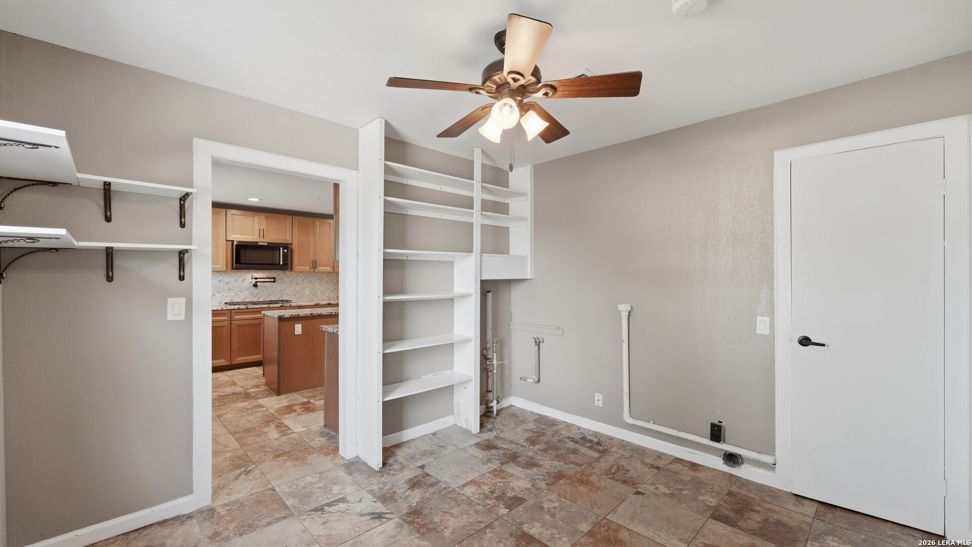 106 County Road 6611 Devine, TX 78016 - Photo 19 of 29 a view of a hallway with a cabinet and a refrigerator