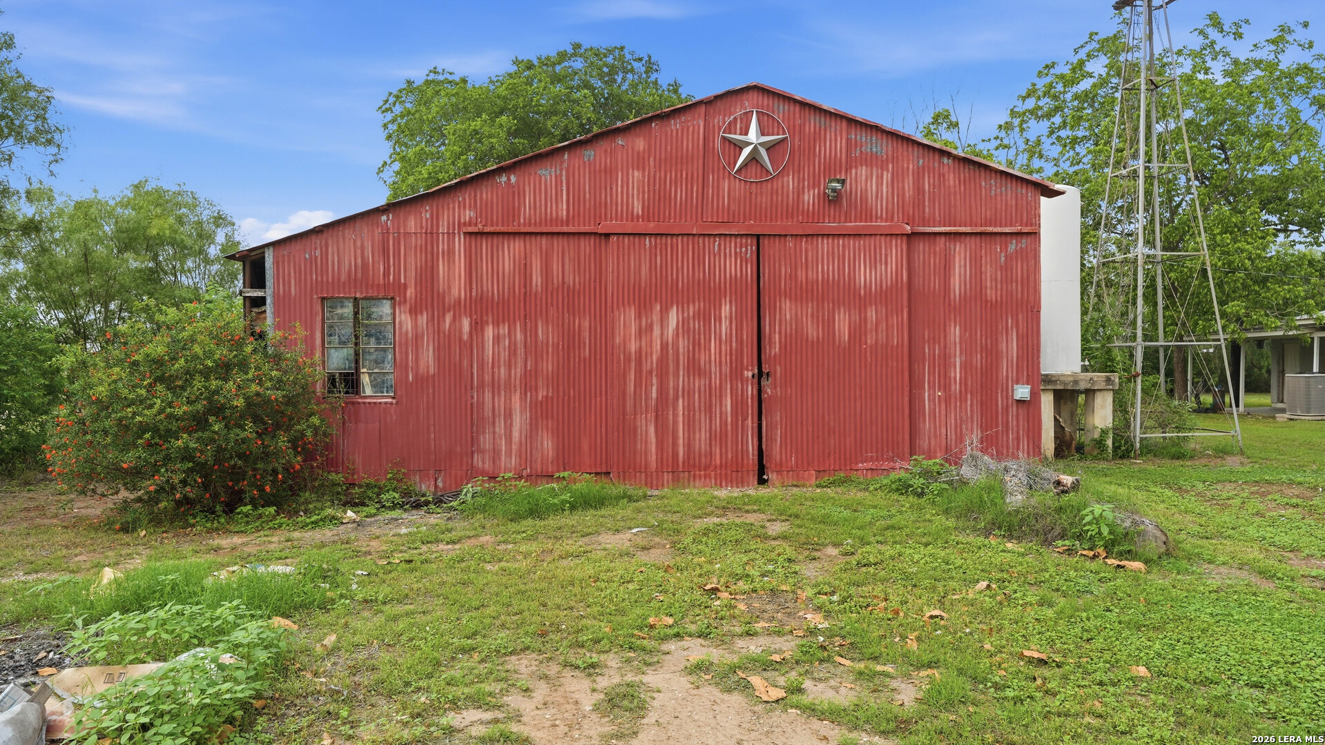 106 County Road 6611 Devine, TX 78016 - Photo 20 of 29 a view of a backyard with potted plants and a large tree