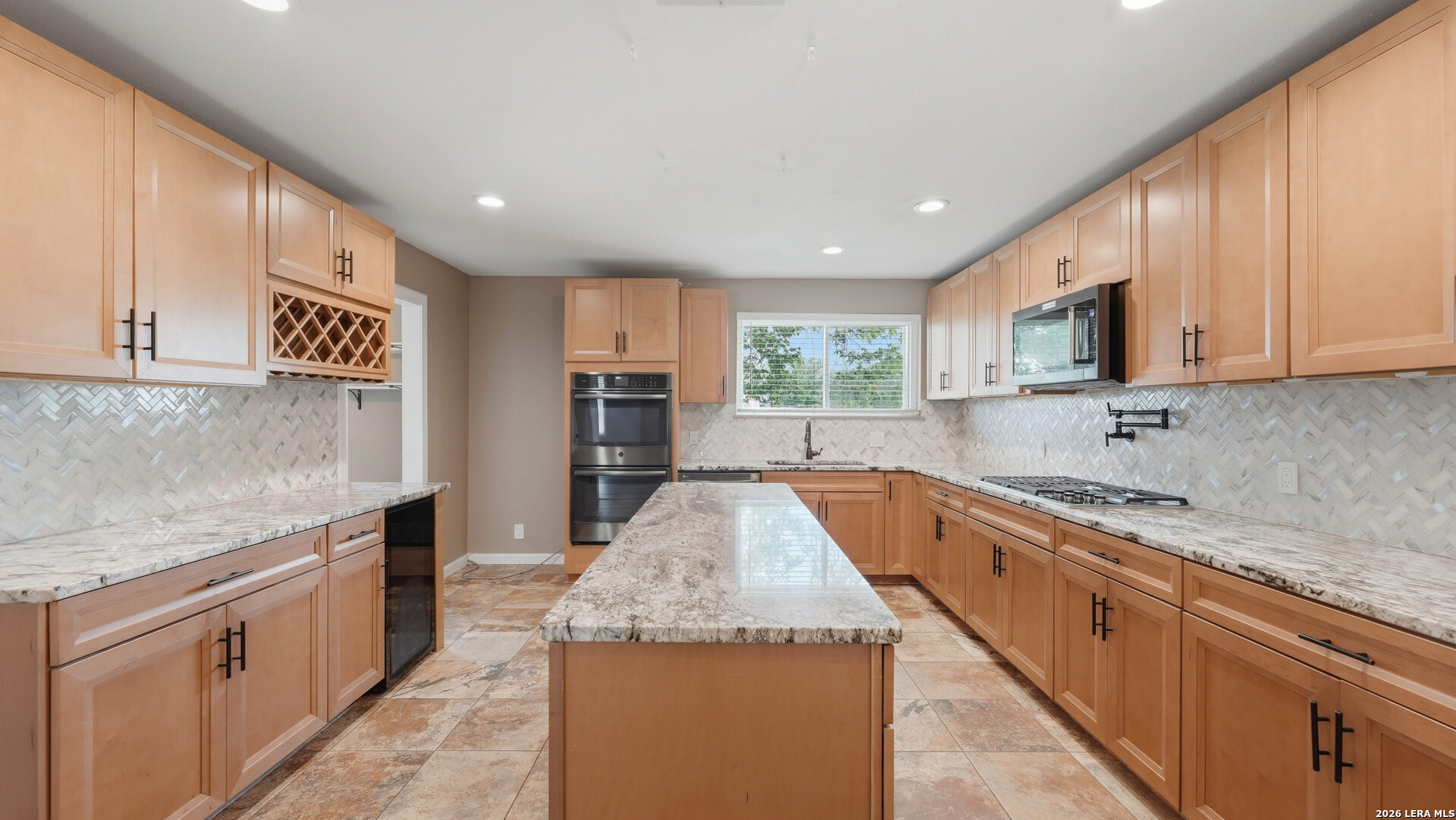 106 County Road 6611 Devine, TX 78016 - Photo 3 of 29 a large kitchen with granite countertop a sink and cabinets