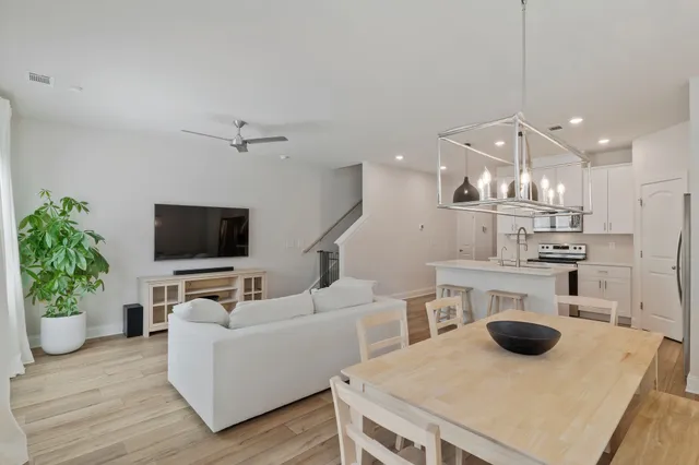 a living room with furniture a flat screen tv and kitchen view