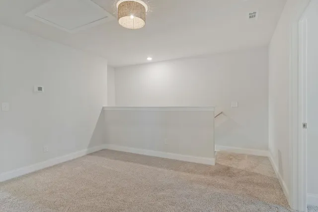 a bed sitting in a bedroom next to a window and a lamp