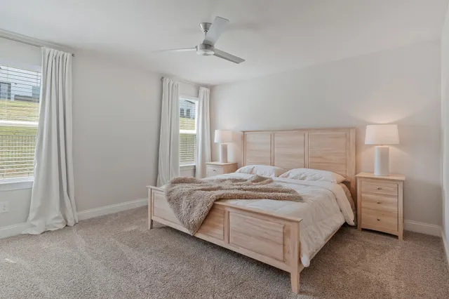 a bedroom with a bed and a chandelier fan