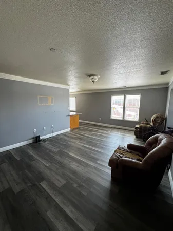 a living room with furniture and a wooden floor