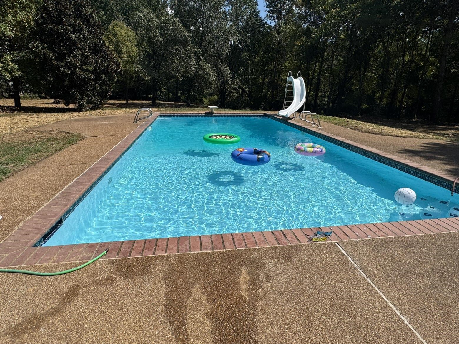 3540 Portersville Road Atoka, TN 38004 - Photo 33 of 37 Rectangular swimming pool with a brick coping, aggregate concrete surround, and a pool slide