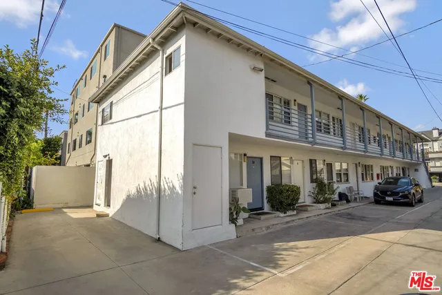 a car parked in front of a white house