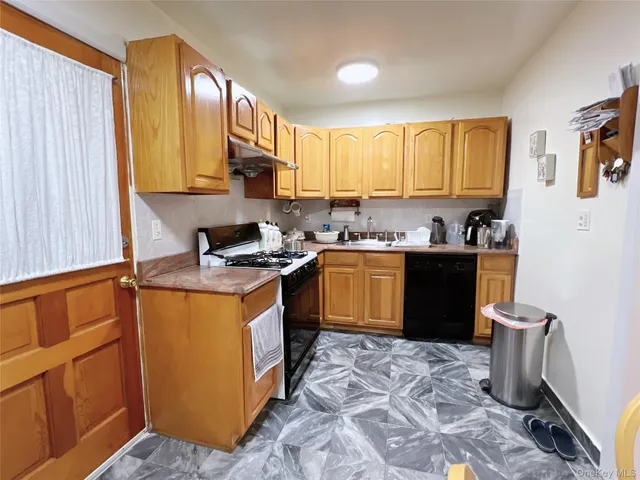 a kitchen with a sink appliances cabinets and a window