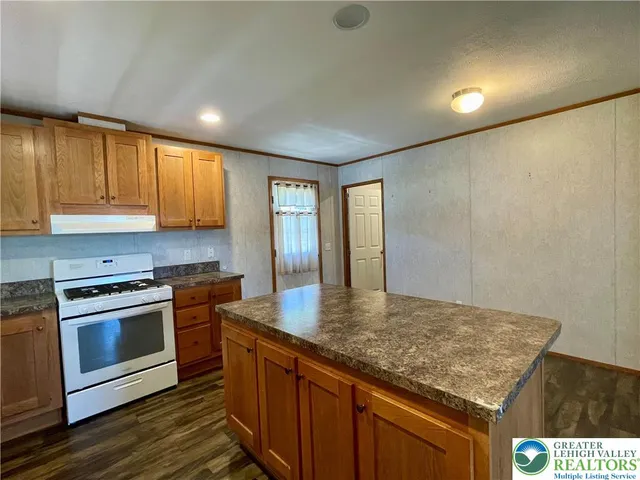a kitchen with stainless steel appliances granite countertop a stove a sink and dishwasher with wooden cabinets
