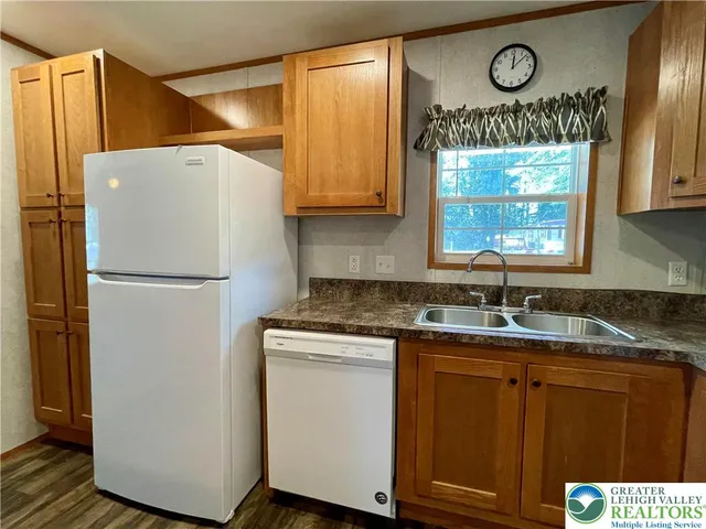 a kitchen with granite countertop wooden floors appliances and sink