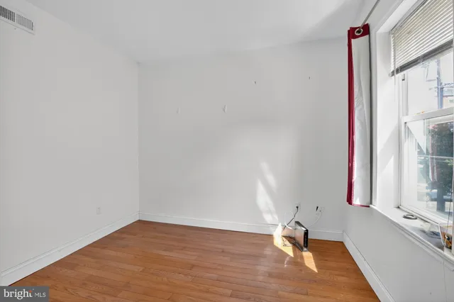 a view of a room with wooden floor and a window