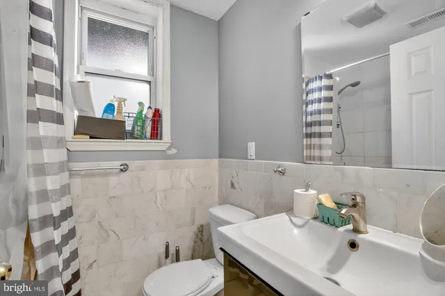 a bathroom with a sink vanity mirror and toilet