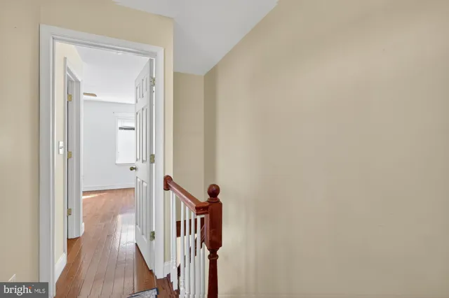 a view of a hallway with wooden floor and closet
