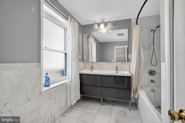 a bathroom with a tub sink shower and mirror
