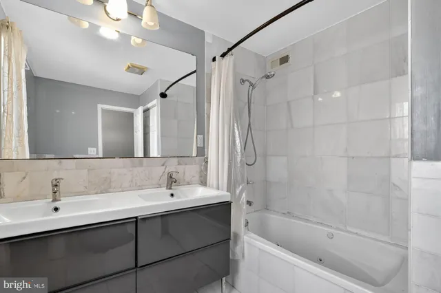 a bathroom with a tub sink mirror and a shower