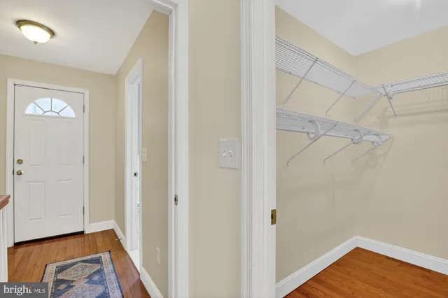 a view of a room with wooden floor and a ceiling fan