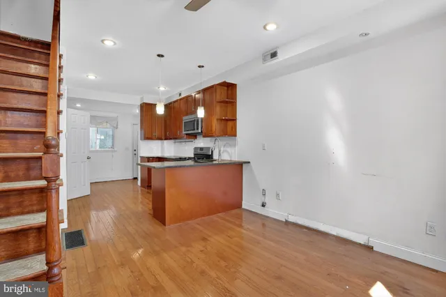 a view of kitchen with stainless steel appliances cabinets and wooden floor