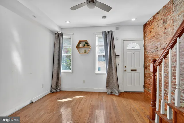 an empty room with wooden floor and entryway