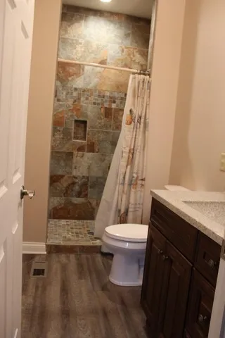 a bathroom with a toilet and a shower
