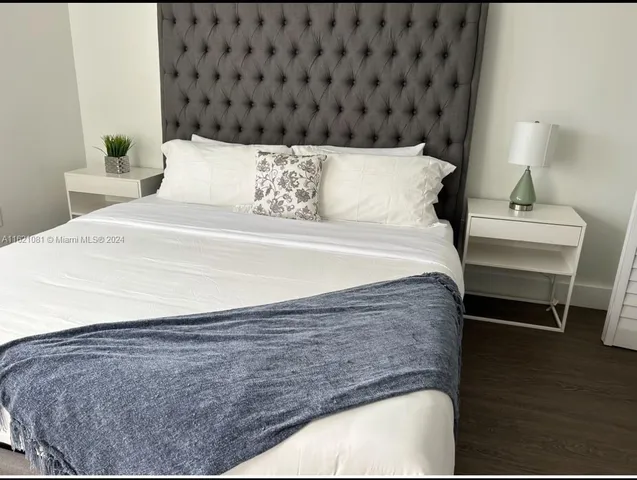 a bed sitting in a bedroom next to a lamp
