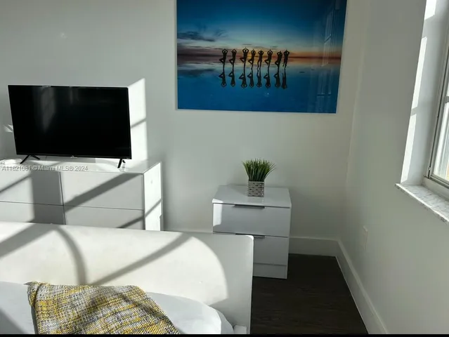 a bedroom with a bed and flat screen tv