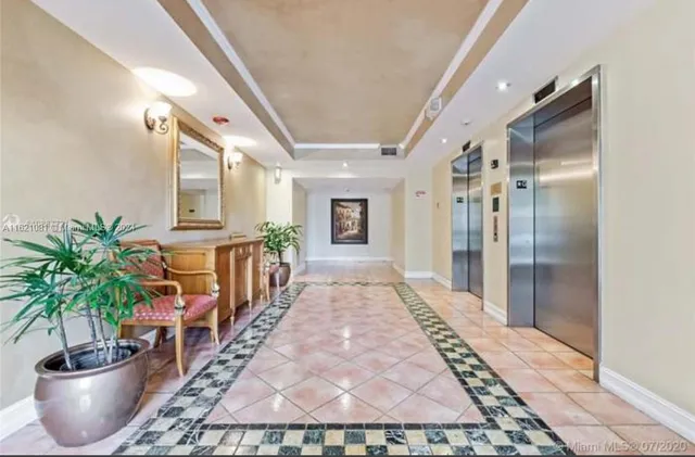 a hallway with wooden floor and a potted plant