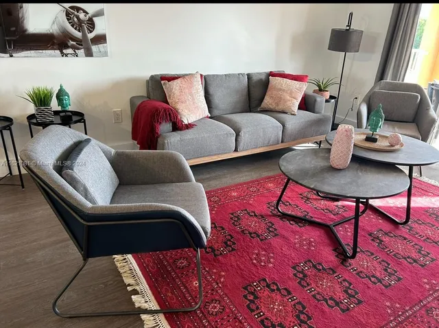 a living room with furniture and wooden floor