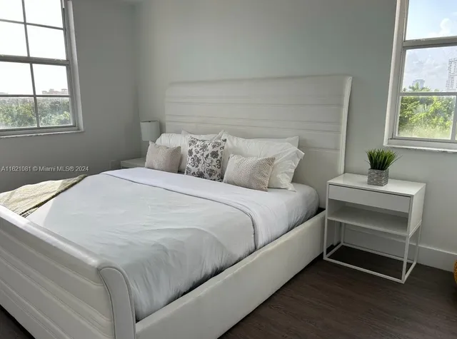 a large bed sitting in a bedroom next to a window