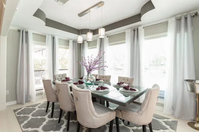 a dining room with furniture a chandelier and wooden floor
