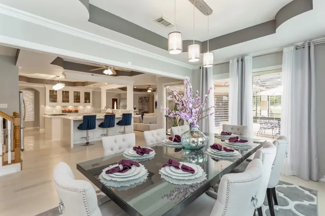 a view of a dining room and livingroom with furniture wooden floor a chandelier
