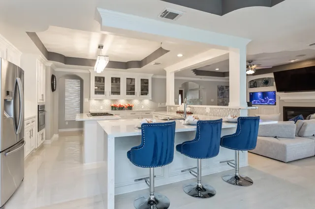 a living room with stainless steel appliances kitchen island granite countertop a couch and cabinets