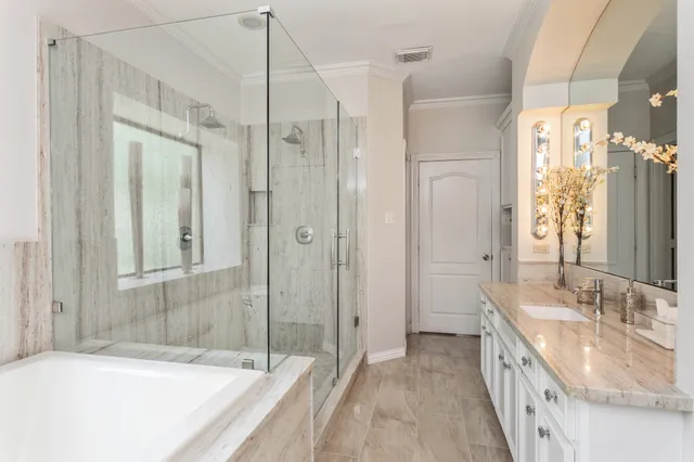 a bathroom with a granite countertop tub sink double vanity and shower