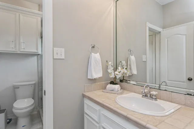 a bathroom with a toilet sink and mirror