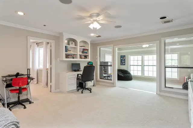 a living room with furniture gym equipment and a ceiling fan