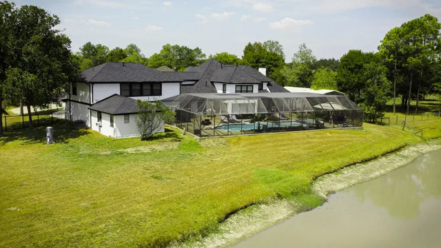 a view of a house with swimming pool next to a yard