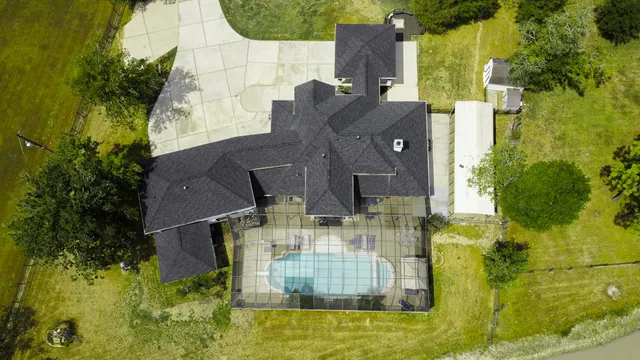 an aerial view of residential houses with outdoor space and trees