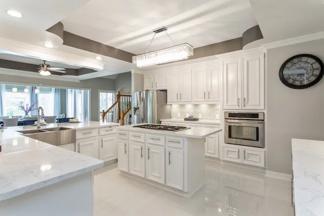 a kitchen with stainless steel appliances granite countertop a stove a sink and a refrigerator