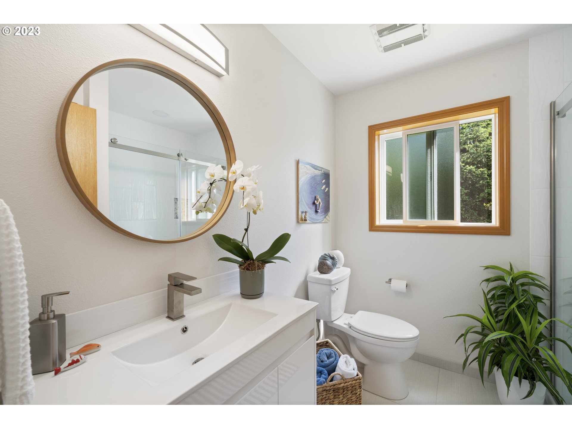 905 Pinewood West Tillamook, OR 97141 - Photo 35 of 44 a bathroom with a sink a mirror a toilet and a window