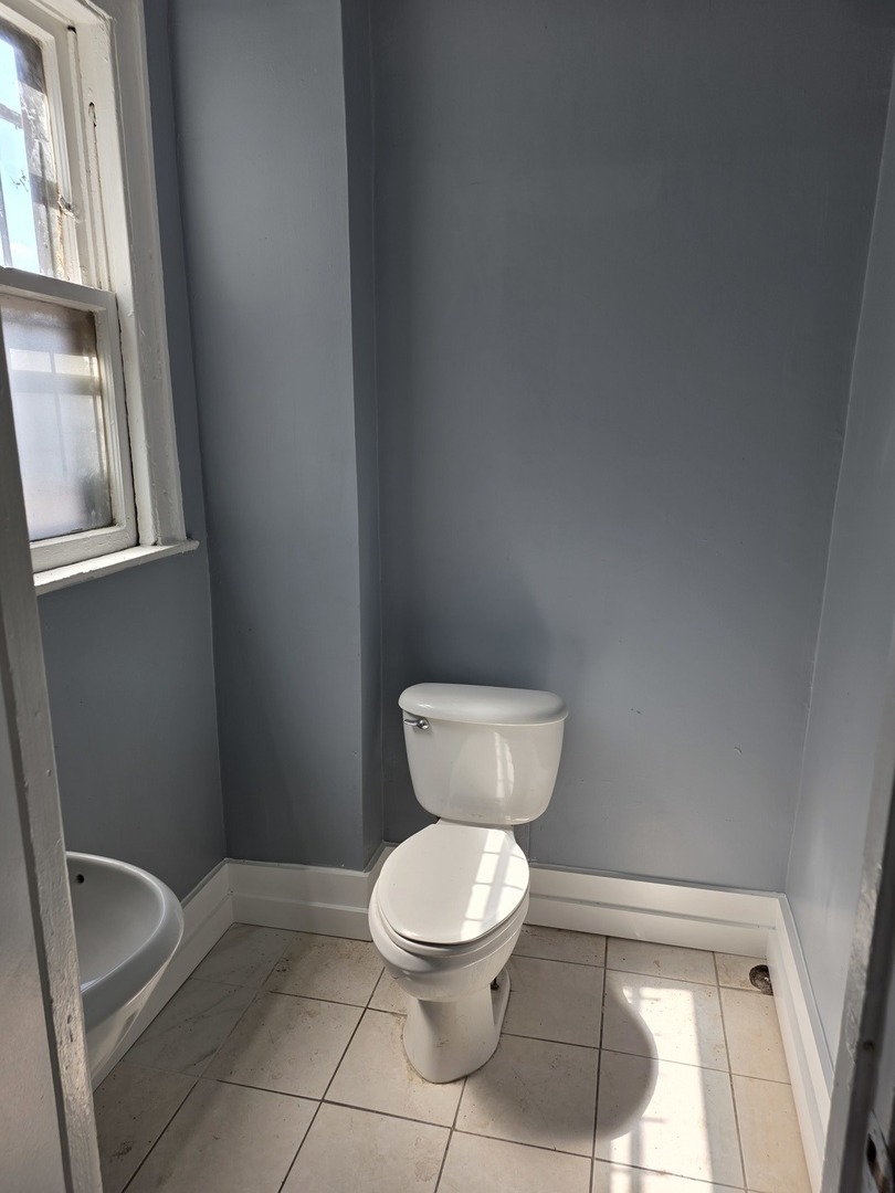 1853 East 79th Street, Unit 2 Chicago, IL 60649 - Photo 13 of 14 a white toilet sitting next to a window