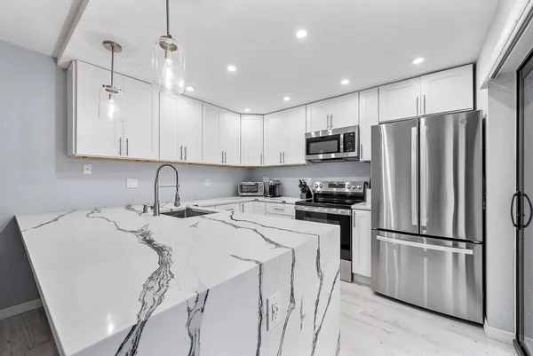 a kitchen with stainless steel appliances granite countertop a refrigerator stove top oven and sink