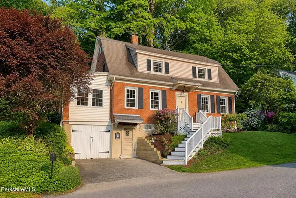 a front view of a house with a garden