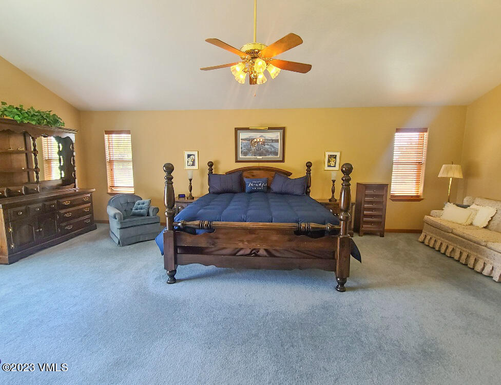 1072 Mesa Drive Eagle, CO 81631 - Photo 24 of 34 a bedroom with a bed and a chandelier