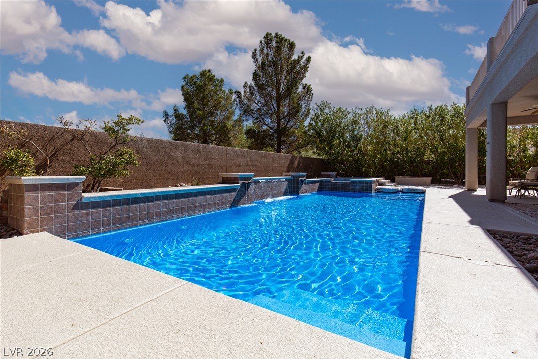 22 Douglas Grove Road Henderson, NV 89052 - Photo 65 of 72 A sparkling pool with elegant tile accents and waterfall features offers refreshing aquatic enjoyment.