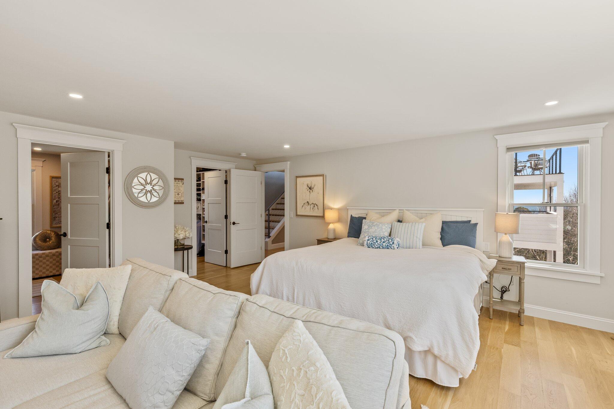 87 Oyster Pond Road Falmouth, MA 02540 - Photo 29 of 105 a bedroom with a large bed and a chandelier