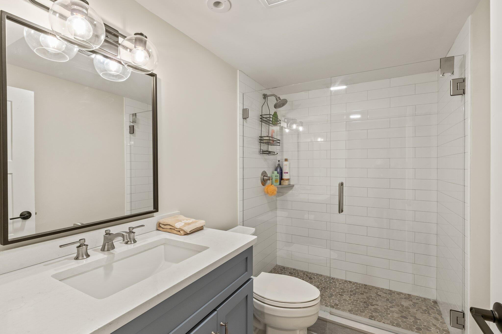 87 Oyster Pond Road Falmouth, MA 02540 - Photo 40 of 105 a bathroom with a sink a toilet a mirror and shower
