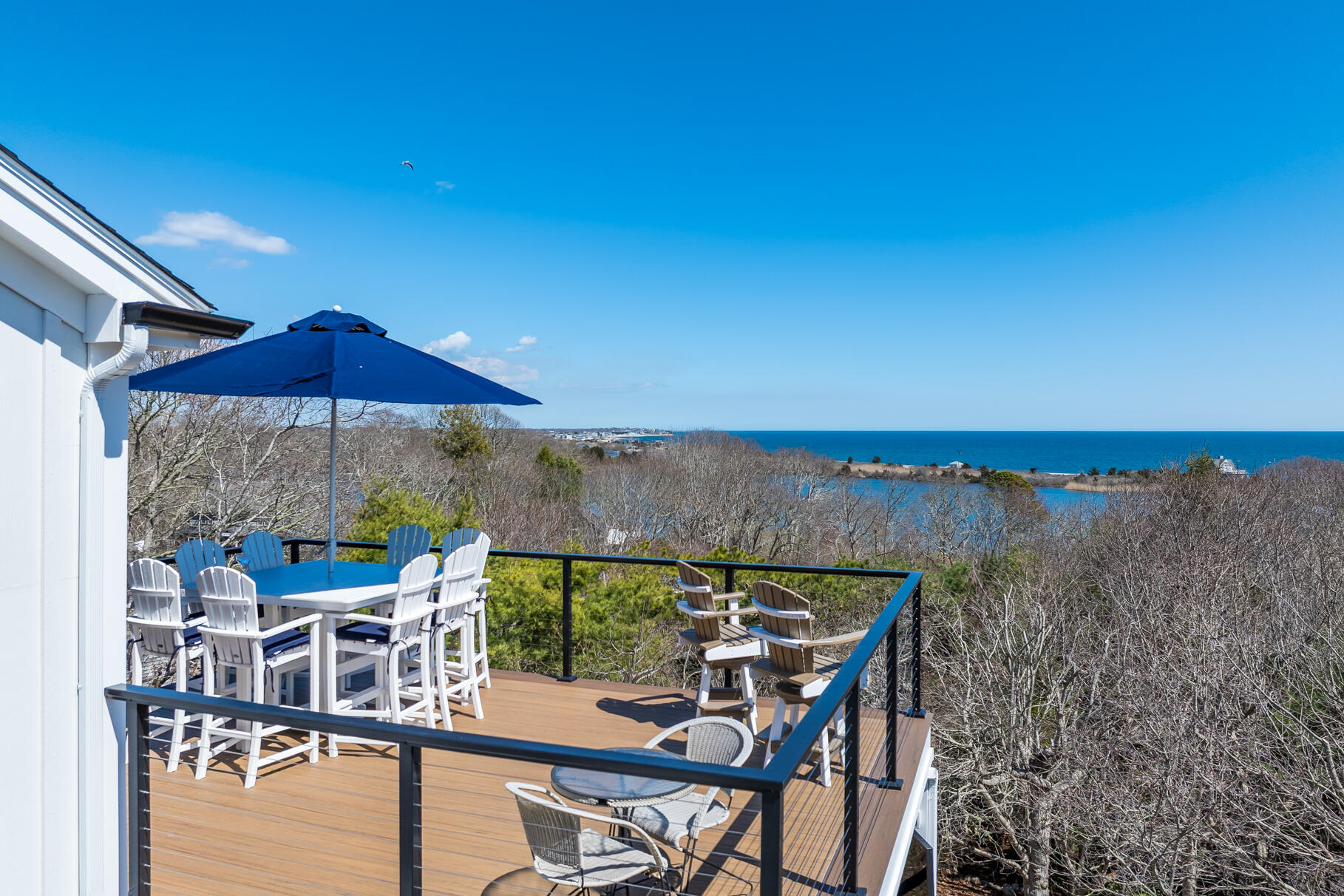 87 Oyster Pond Road Falmouth, MA 02540 - Photo 79 of 105 a view of a balcony with furniture and an umbrella
