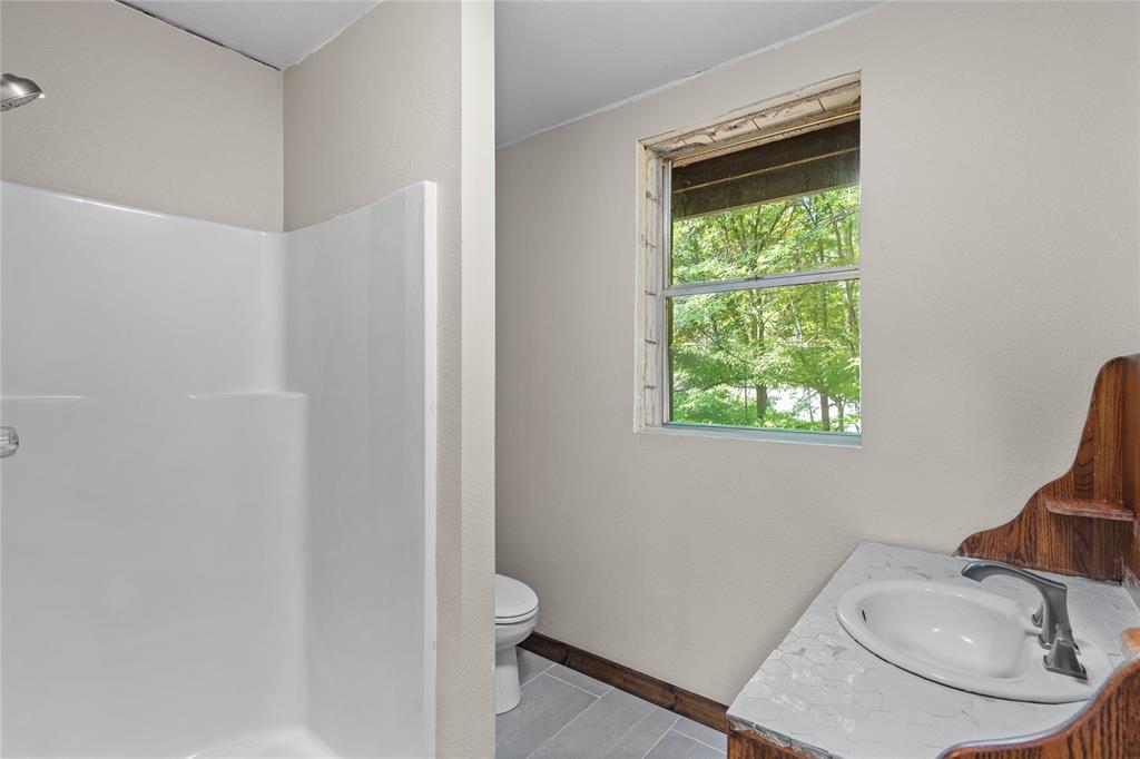 295 Coleman Road Homer, LA 71040 - Photo 28 of 38 a bathroom with a granite countertop sink toilet and a mirror