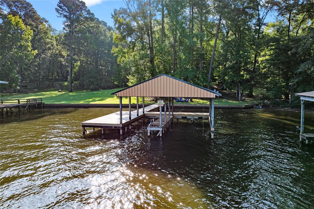 295 Coleman Road Homer, LA 71040 - Photo 3 of 38 a view of a lake with a table and chairs under an umbrella
