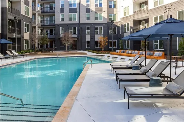 a view of a building with a swimming pool and sitting area