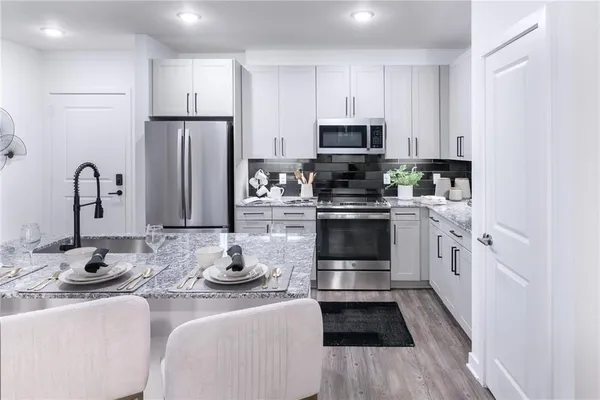 a kitchen with stainless steel appliances kitchen island granite countertop a sink and cabinets