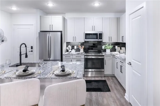 a kitchen with stainless steel appliances kitchen island granite countertop a sink and cabinets
