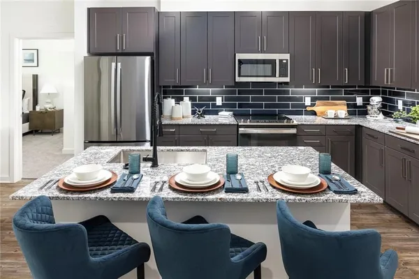 a kitchen with a table chairs stove and a microwave